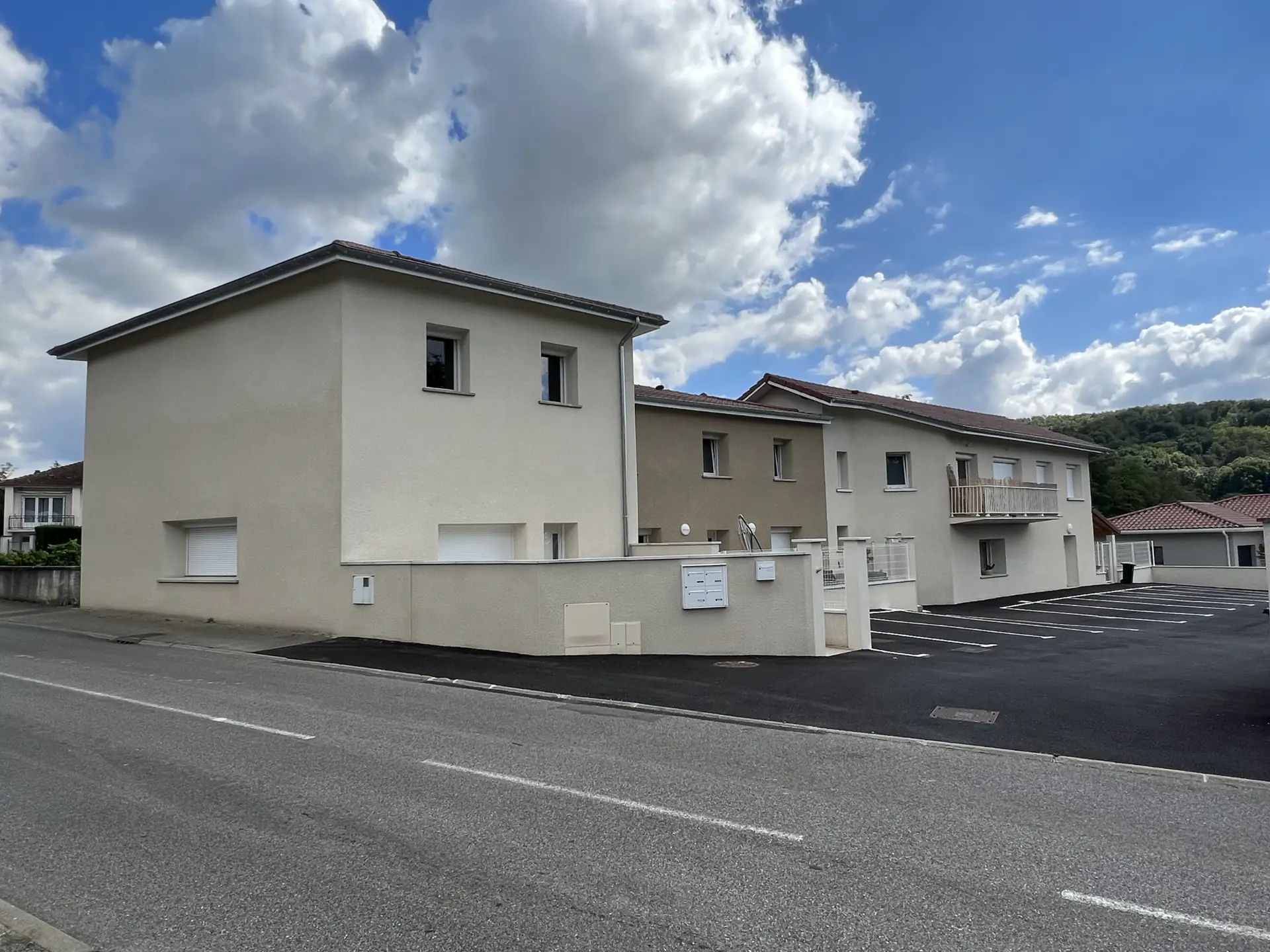 Bâtiments de logements aux façades claires avec parking à Vernioz, en Isère