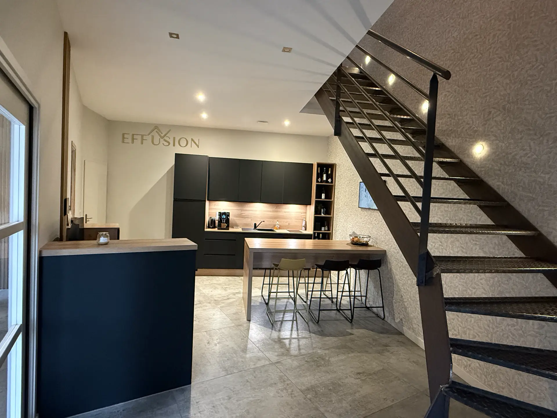 Espace cuisine et escalier métallique dans les locaux d'Effusion à Vernioz, en Isère