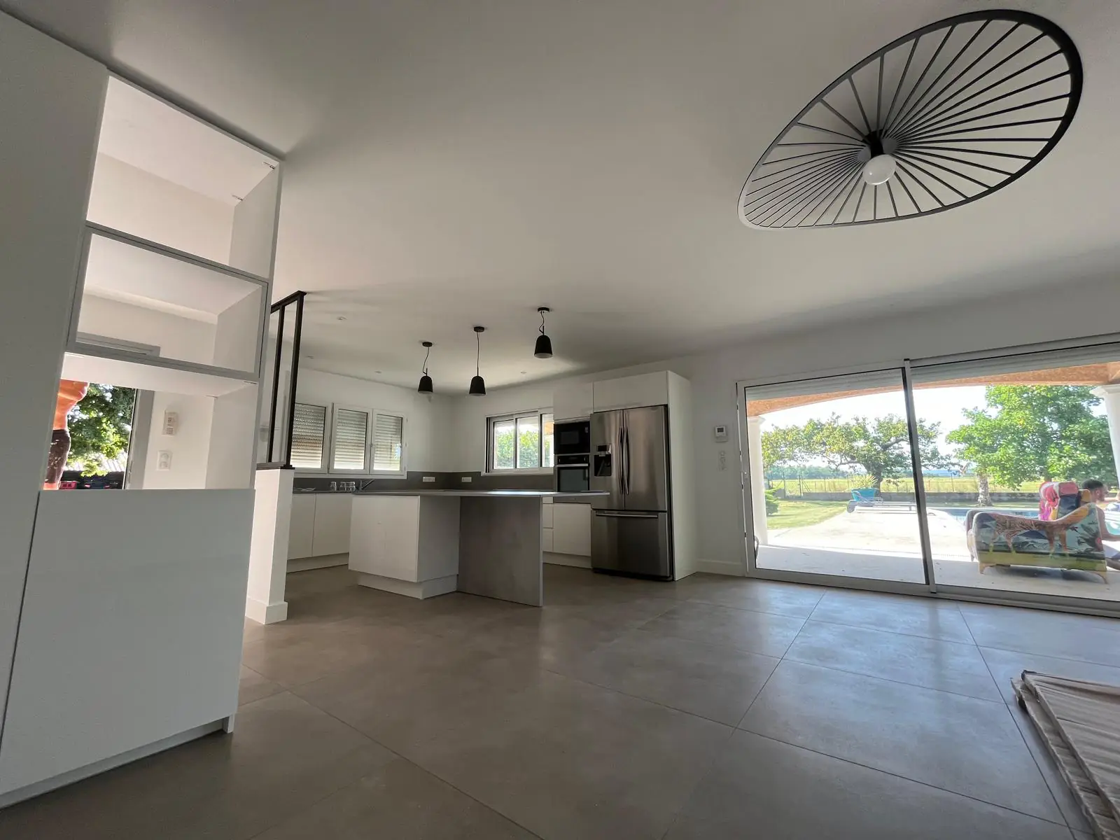 Cuisine ouverte et grande baie vitrée dans une maison individuelle rénovée